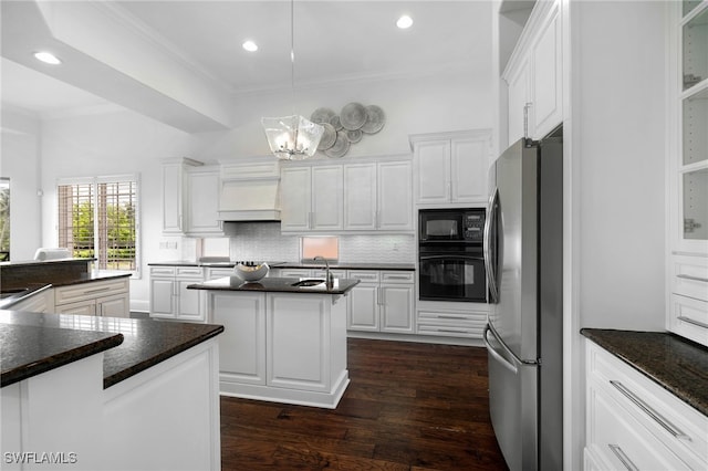 10692 Mirasol Dr Unit 1004, Miromar Lakes, FL 33913 - kitchen with black appliances, a center island with sink, ornamental molding, dark wood finished floors, and backsplash