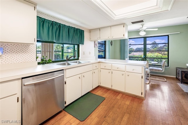 938 Charlemagne Blvd, Naples, FL 34112 - kitchen featuring dishwasher, a sink, light countertops, a raised ceiling, and light wood-type flooring