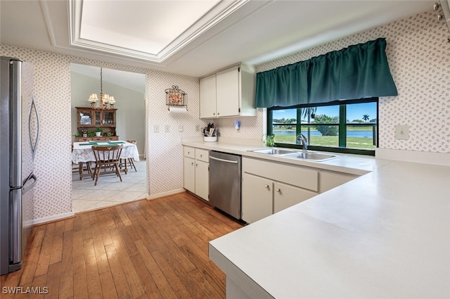 938 Charlemagne Blvd, Naples, FL 34112 - kitchen with appliances with stainless steel finishes, wallpapered walls, a sink, a chandelier, and a raised ceiling