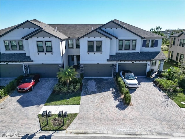 4564 Almada Ln, Wesley Chapel, FL 33543 - townhome / multi-family property with an attached garage, driveway, a shingled roof, and stucco siding