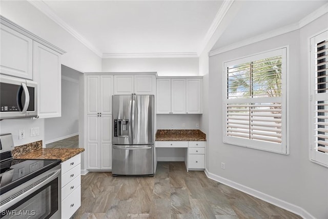 2432 Ravenna Blvd Unit 4, Naples, FL 34109 - kitchen featuring appliances with stainless steel finishes, built in study area, white cabinetry, ornamental molding, and dark stone counters