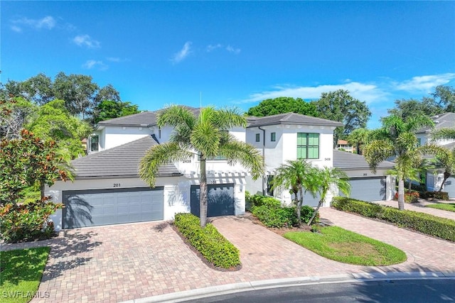 2432 Ravenna Blvd Unit 4, Naples, FL 34109 - view of front facade featuring stucco siding, decorative driveway, and a garage