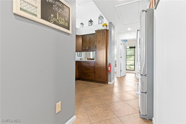 15138 Sam Snead Ln, North Fort Myers, FL 33917 - hallway featuring attic access, light tile patterned floors, and baseboards