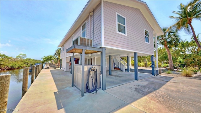 8161 Moyer Ln, Bokeelia, FL 33922 - view of front of property featuring a carport, stairs, a patio area, a dock, and a water view