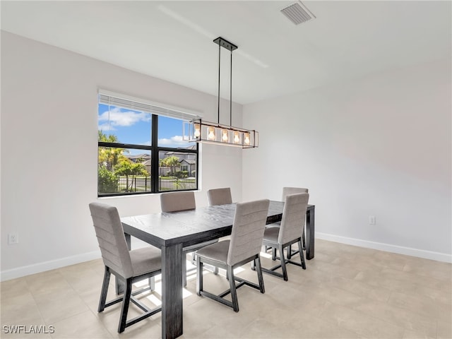 dining space with baseboards and a chandelier