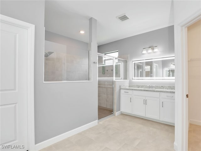 bathroom with a shower stall, vanity, and baseboards