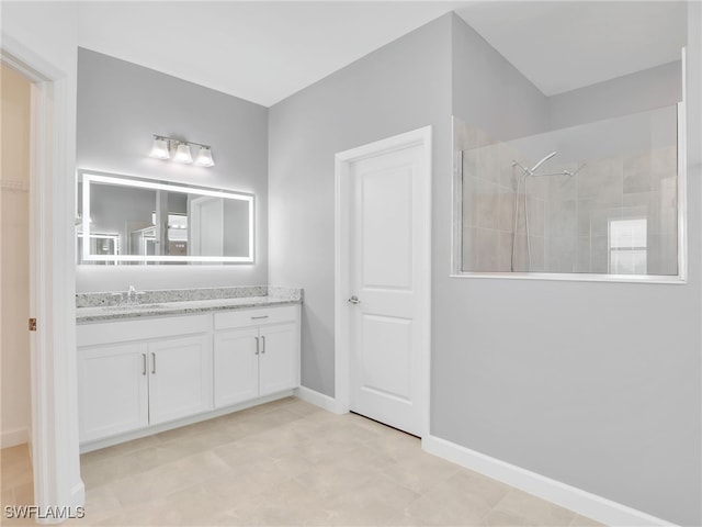 bathroom featuring a walk in shower, vanity, and baseboards