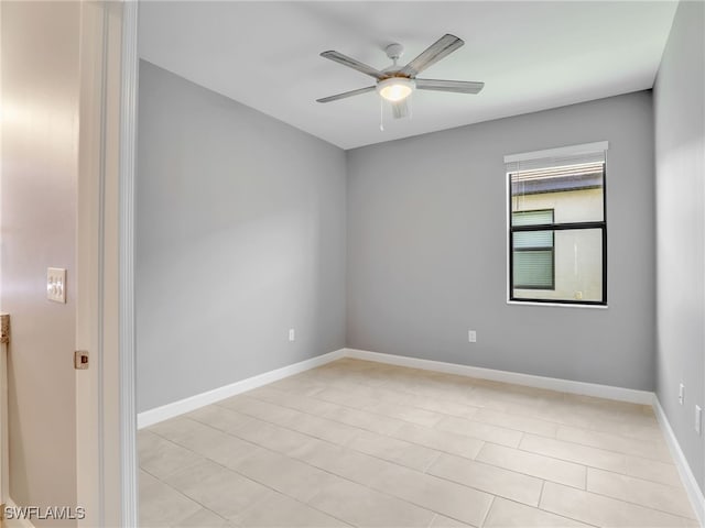 spare room with ceiling fan, baseboards, and light tile patterned floors