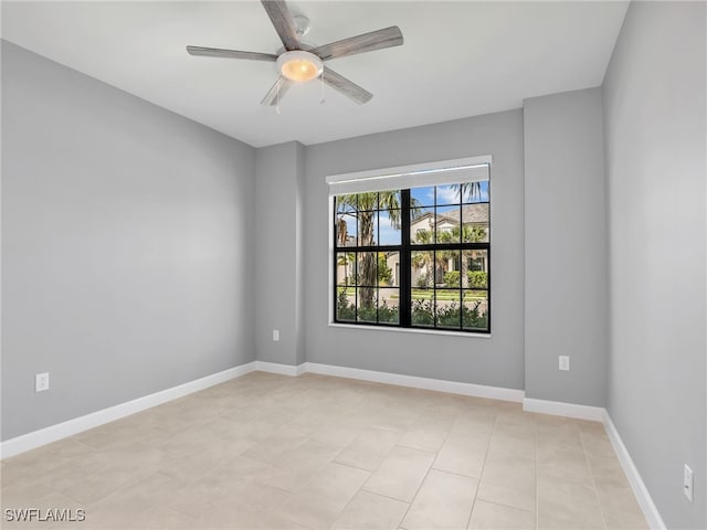 empty room featuring ceiling fan, baseboards, and light tile patterned floors