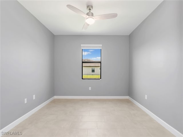 empty room with a ceiling fan and baseboards
