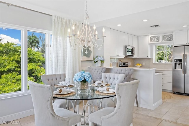 dining space with a chandelier, healthy amount of natural light, light tile patterned floors, baseboards, and recessed lighting