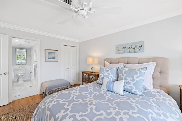 bedroom featuring crown molding, wood finished floors, connected bathroom, a closet, and a ceiling fan