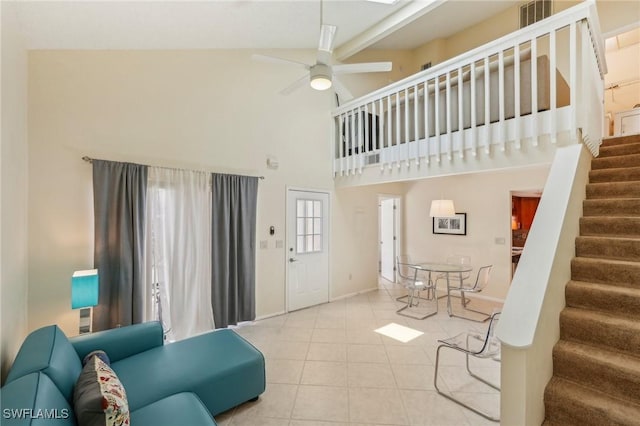 living room featuring high vaulted ceiling, ceiling fan, tile patterned flooring, stairs, and baseboards