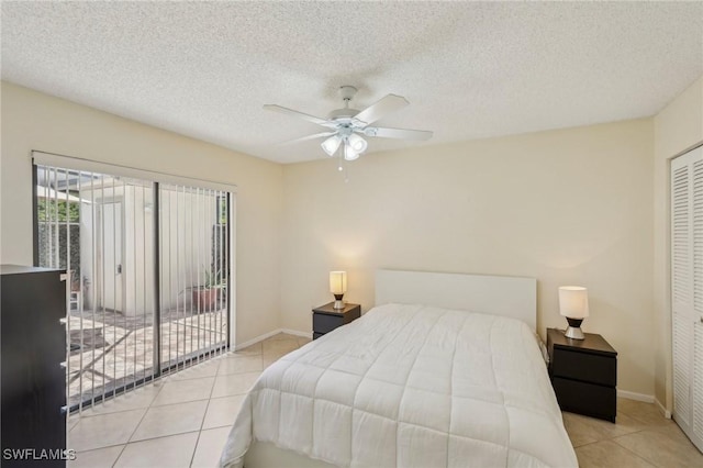 tiled bedroom featuring access to exterior, baseboards, a ceiling fan, a textured ceiling, and a closet