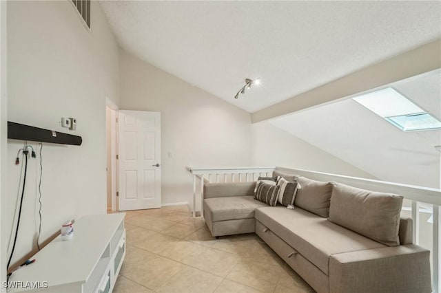 living area with vaulted ceiling, a skylight, and light tile patterned floors