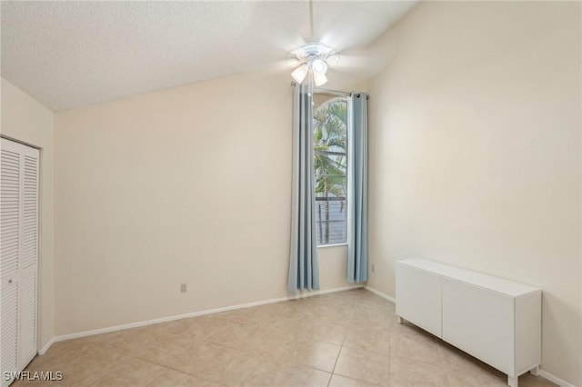 unfurnished bedroom featuring light tile patterned floors, ceiling fan, baseboards, and a closet