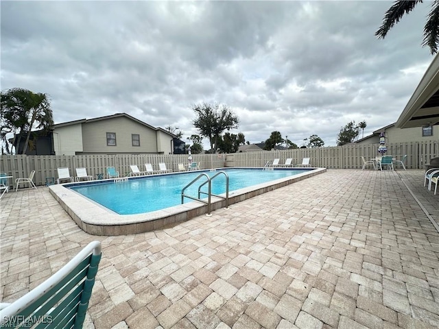 community pool with a patio and a fenced backyard