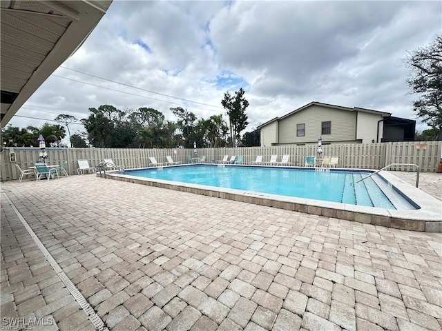 community pool featuring a patio and fence