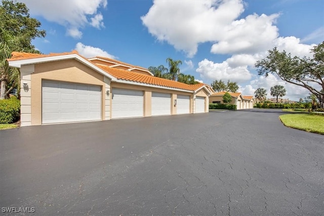 26740 Rosewood Pointe Ln Unit 102, Bonita Springs, FL 34135 - view of front of property featuring community garages, a tiled roof, and stucco siding