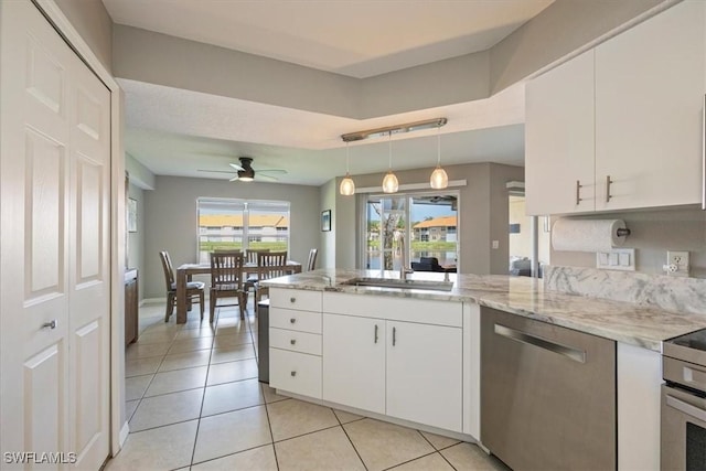 26740 Rosewood Pointe Ln Unit 102, Bonita Springs, FL 34135 - kitchen with stainless steel dishwasher, a sink, a peninsula, light tile patterned floors, and white cabinets