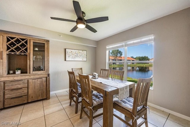 26740 Rosewood Pointe Ln Unit 102, Bonita Springs, FL 34135 - dining space with light tile patterned floors, baseboards, a ceiling fan, and a water view