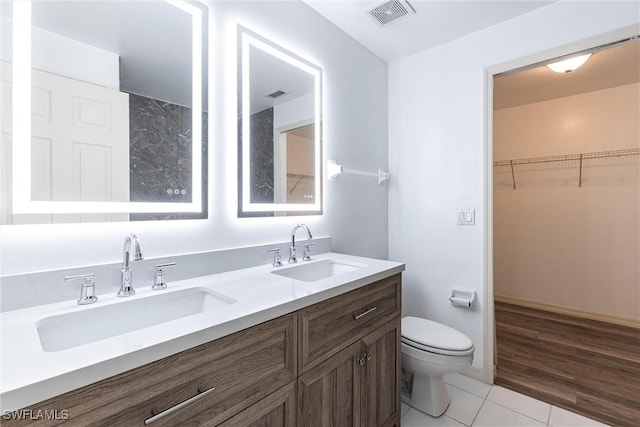 497 Bethany Village Cir, Lehigh Acres, FL 33936 - bathroom with toilet, tile patterned floors, double vanity, and a spacious closet