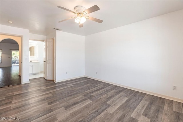 497 Bethany Village Cir, Lehigh Acres, FL 33936 - empty room with arched walkways, a ceiling fan, dark wood-style floors, and baseboards
