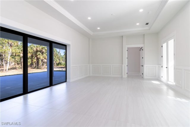 2583 18th Ave SE, Naples, FL 34117 - spare room featuring a decorative wall, a raised ceiling, recessed lighting, and wainscoting