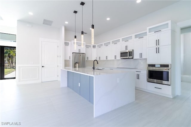 2583 18th Ave SE, Naples, FL 34117 - kitchen with appliances with stainless steel finishes, a sink, a large island, white cabinets, and recessed lighting