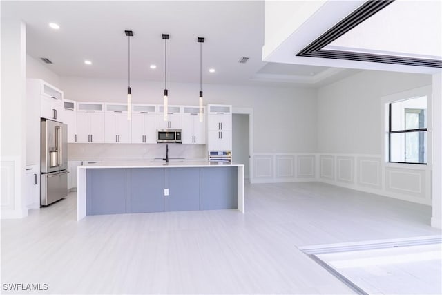 2583 18th Ave SE, Naples, FL 34117 - kitchen featuring stainless steel appliances, light countertops, white cabinetry, a spacious island, and hanging light fixtures