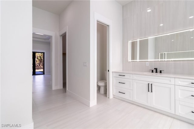 2583 18th Ave SE, Naples, FL 34117 - bathroom featuring toilet, vanity, baseboards, and wood finished floors