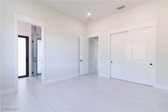 2583 18th Ave SE, Naples, FL 34117 - unfurnished bedroom featuring a closet, light wood-style flooring, and baseboards