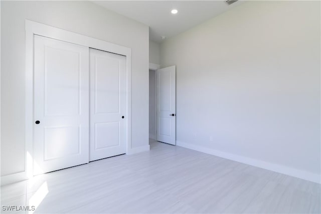 2583 18th Ave SE, Naples, FL 34117 - unfurnished bedroom featuring baseboards, light wood-type flooring, a closet, and recessed lighting