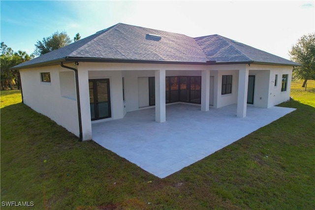 2583 18th Ave SE, Naples, FL 34117 - back of house featuring a patio area, a lawn, an attached carport, and stucco siding