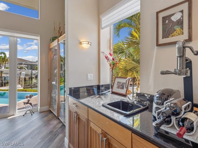 622 Bimini Ave, Marco Island, FL 34145 - kitchen with a sink, wood finished floors, dark stone countertops, and baseboards