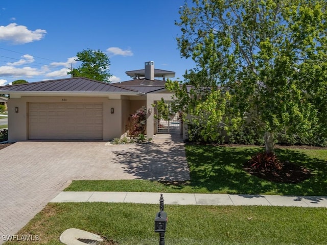 622 Bimini Ave, Marco Island, FL 34145 - view of front of home featuring a standing seam roof, stucco siding, an attached garage, and metal roof