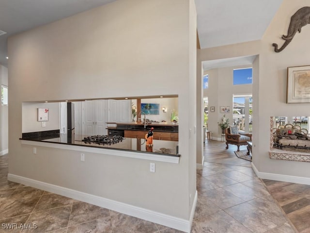622 Bimini Ave, Marco Island, FL 34145 - kitchen featuring a sink, baseboards, a high ceiling, gas cooktop, and dark countertops