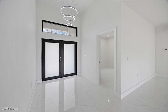 3300 18th St W, Lehigh Acres, FL 33971 - entrance foyer featuring light marble finish floors, baseboards, a towering ceiling, and french doors