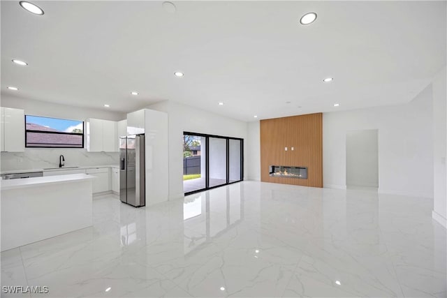 3300 18th St W, Lehigh Acres, FL 33971 - unfurnished living room with light marble finish flooring, a sink, and recessed lighting