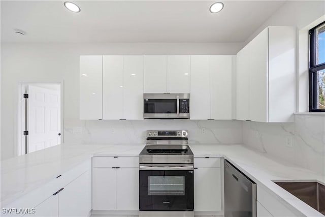 3300 18th St W, Lehigh Acres, FL 33971 - kitchen featuring stainless steel appliances, white cabinets, modern cabinets, recessed lighting, and a peninsula