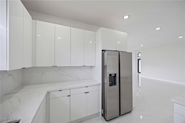 3300 18th St W, Lehigh Acres, FL 33971 - kitchen with stainless steel fridge with ice dispenser, light marble finish floors, white cabinetry, modern cabinets, and recessed lighting