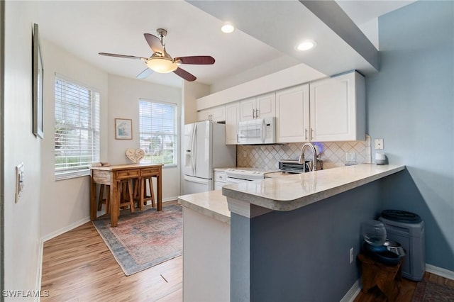 9750 Sassafras Ct, Estero, FL 33928 - kitchen with white appliances, backsplash, light countertops, light wood finished floors, and recessed lighting