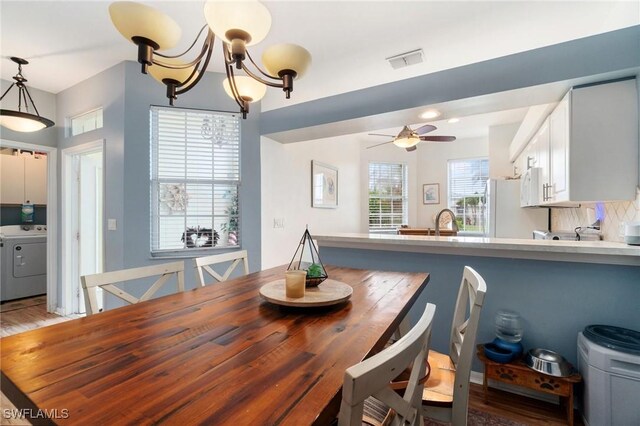 9750 Sassafras Ct, Estero, FL 33928 - dining space with washer / clothes dryer, ceiling fan, light wood-style floors, and a chandelier
