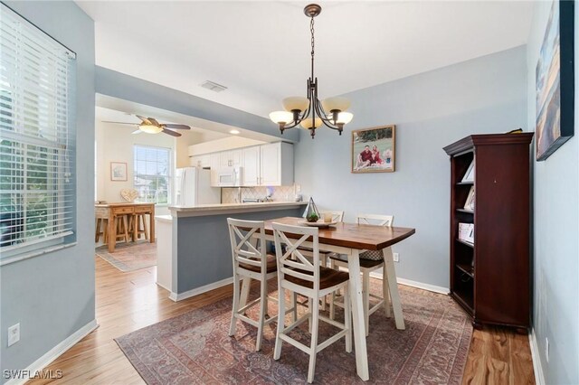 9750 Sassafras Ct, Estero, FL 33928 - dining area with light wood finished floors, a chandelier, baseboards, and a ceiling fan