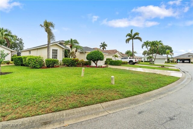 9750 Sassafras Ct, Estero, FL 33928 - view of front of property with concrete driveway, a residential view, a front lawn, and stucco siding