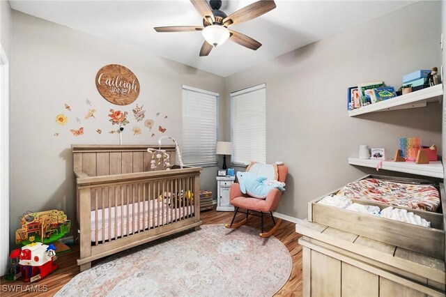 9750 Sassafras Ct, Estero, FL 33928 - bedroom with a crib, wood finished floors, baseboards, and a ceiling fan