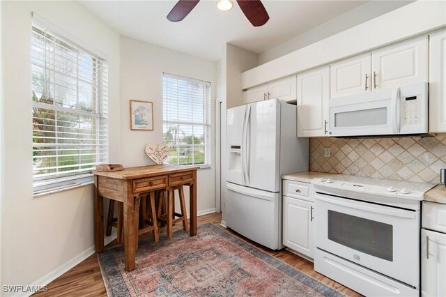 9750 Sassafras Ct, Estero, FL 33928 - kitchen with white appliances, healthy amount of natural light, light wood finished floors, and light countertops