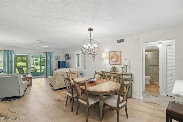 dining space featuring a chandelier, ceiling fan, and a textured ceiling