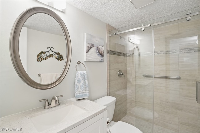 full bath with a textured ceiling, toilet, a stall shower, and vanity