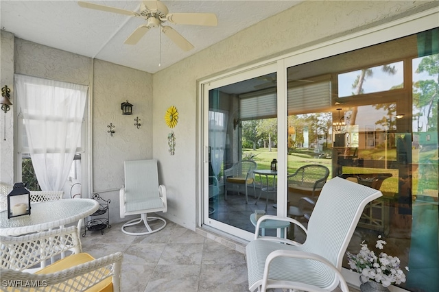 sunroom / solarium featuring ceiling fan and plenty of natural light